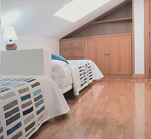 a bedroom with two beds and a wooden floor at alaia apartamento in Zarautz