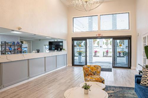 a lobby with a waiting area with a chair and tables at Rodeway Inn Clearwater - Central in Clearwater