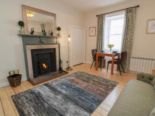 a living room with a fireplace and a table at South Segganwell - Culzean Castle in Maybole