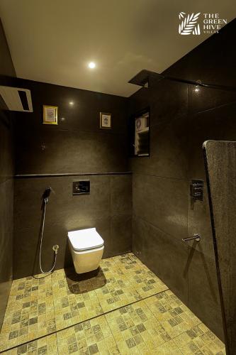 a bathroom with a toilet and a shower at The Green Hive Villas in Belgaum