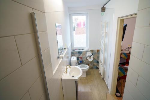 a small bathroom with a sink and a toilet at Lumiere Studio 2 in Sfântu-Gheorghe