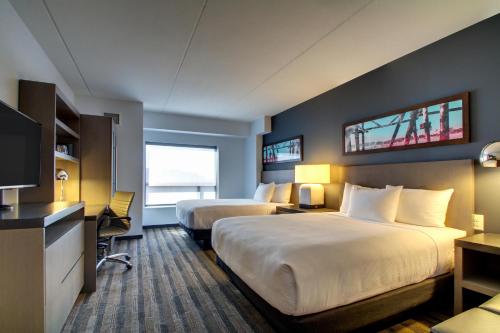 a hotel room with two beds and a television at Hyatt House Chicago/Evanston in Evanston