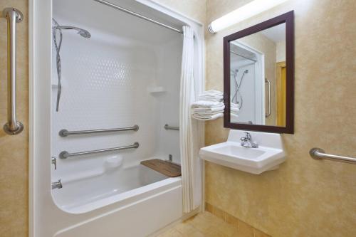 a bathroom with a shower and a sink and a mirror at Quality Inn Marshall near I-69 in Marshall
