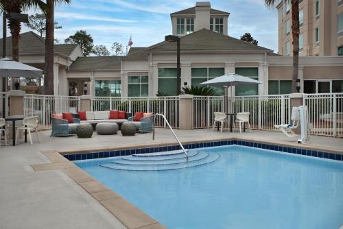 a swimming pool in front of a house at Hilton Garden Inn Tallahassee Central in Tallahassee