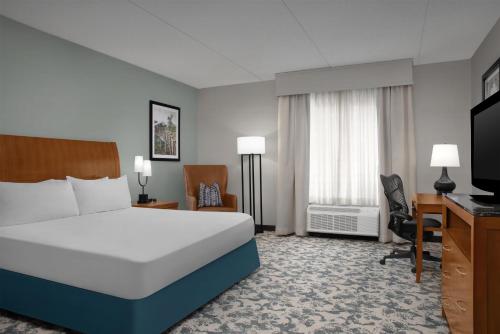 a bedroom with a bed and a desk and a television at Hilton Garden Inn Tallahassee Central in Tallahassee