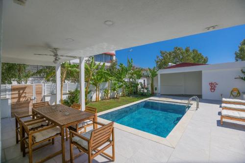 a patio with a table and chairs and a swimming pool at Traditional Seaside Stone Villa with Private Pool in Bodrum City