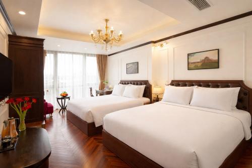 a hotel room with two beds and a chandelier at Du Palace Hotel & Travel in Hanoi