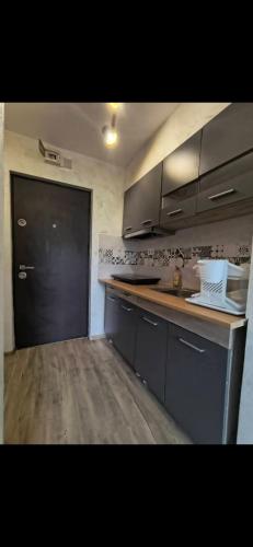 a kitchen with a counter and a black door at Studio roberto in Piatra Neamţ