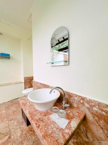 a bathroom with a sink and a mirror at Lorin Resort Belitung in Sijuk