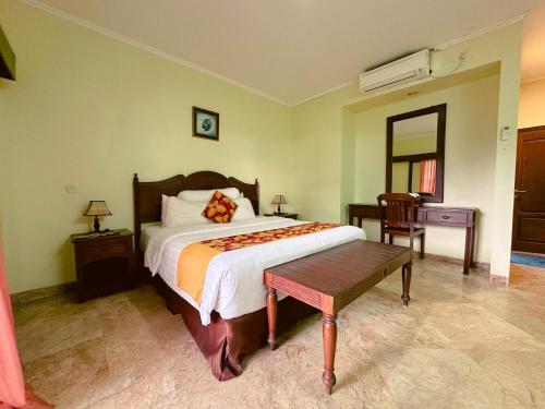 a bedroom with a bed and a table and a mirror at Lorin Resort Belitung in Sijuk