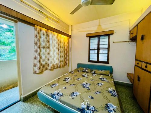 a bedroom with a bed in a room with a window at Flora 2bhk Kothrud MIT WPU in Pune