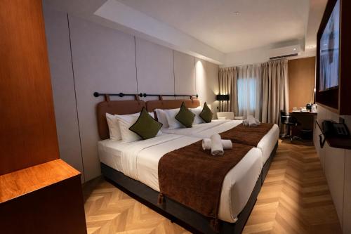 a hotel room with a large bed and a television at The Green Hall in George Town