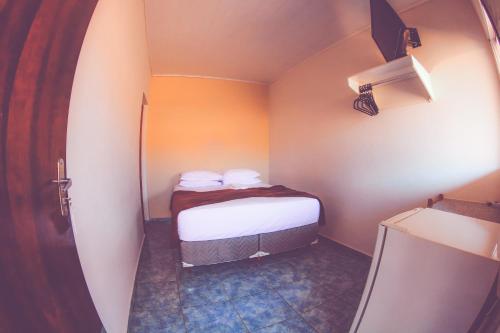 a small room with a small bed in it at Vitória Hotel in Monte Alto