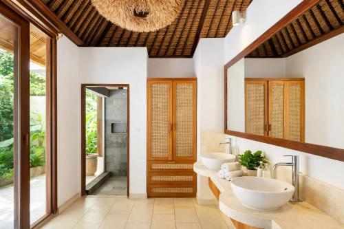 a bathroom with two sinks and two mirrors at VillaJewel Bali in Dalung