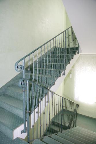 a staircase with a greensteel railing in a house at Hotel Villa Rosa in Grado