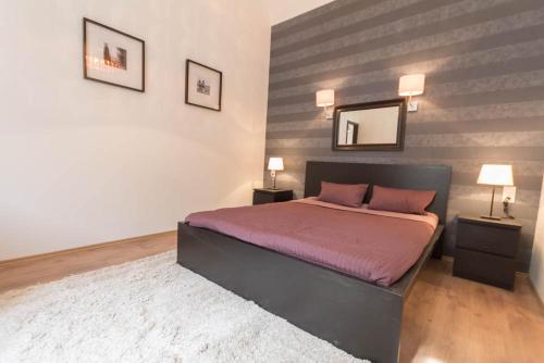 ブダペストにあるLuxury Apartment by Hi5-Városház Suiteのベッドルーム1室(ベッド1台、壁掛け鏡付)