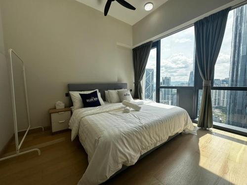 a bedroom with a large bed and a large window at Star Residence KLCC By BluekeyKL in Kuala Lumpur