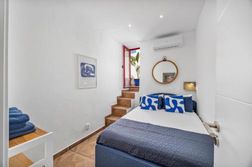 a bedroom with a blue bed and a staircase at Coral Alvor Old Town Marina Townhouses Collection in Alvor