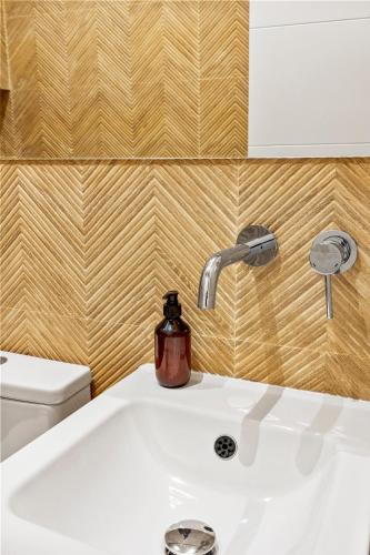 a bathroom sink with a soap dispenser on top of it at Coral Alvor Old Town Marina Townhouses Collection in Alvor