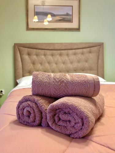 a pile of towels sitting on top of a bed at Athevillas Antonis in Mína