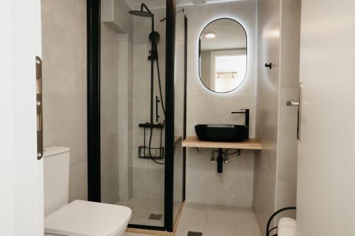 a bathroom with a toilet and a sink and a mirror at The Minimal Apartments 3Floors in Loutra Edipsou