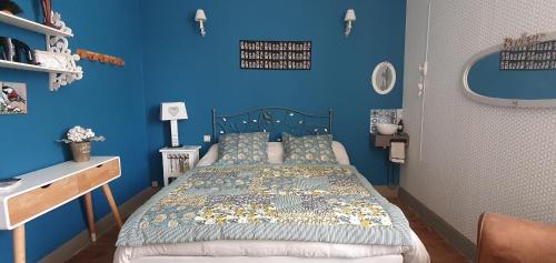 a blue bedroom with a bed and a blue wall at Pause Campagne - Chambres d'Hôtes in Pouy-de-Touges