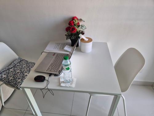 a white table with a laptop and a vase of flowers at Paradise Now in Jomtien Beach