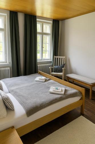 a bedroom with a large bed and a chair at Kloster Altenhohenau FHN in Griesstätt