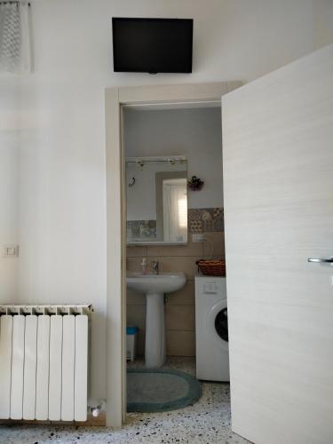 a bathroom with a sink and a television on a wall at L'antica Terrazzella in Vasto