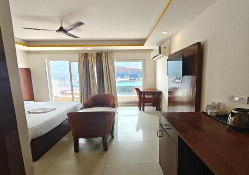 a hotel room with a bed and a desk and a kitchen at VedaVibe Tapovan in Rishīkesh