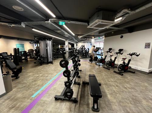 a gym with rows of treadmills and exercise bikes at Multiple 2-Bedroom Apartments near Harry Potter Studios - 2-Minute walk to Bushey Station - 20 Minutes to London Euston - Ideal for Families & Business - Free Parking in Watford