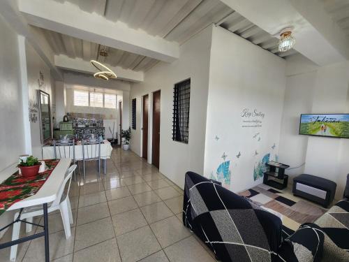 a living room with a couch and a table and chairs at Caishen Apartelle 301 in Silang