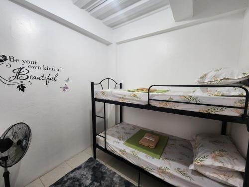 a room with two bunk beds and a fan at Caishen Apartelle 301 in Silang