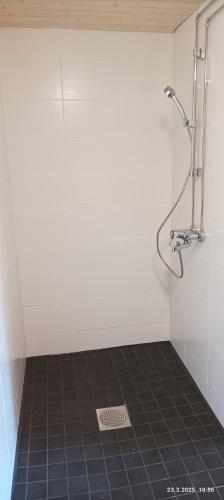 a shower in a bathroom with a tile floor at Veteli in Veteli