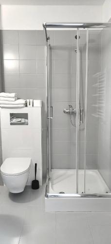 a white bathroom with a shower and a toilet at Noclegi Sezam in Łańcut