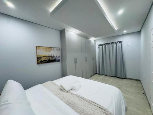 a white bedroom with a large white bed in it at DECADE Self-catering in Swakopmund