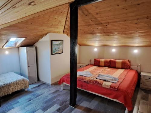 a bedroom with a bed in a room with wooden ceilings at Къща за гости Пъстрина in Sŭbotkovtsi