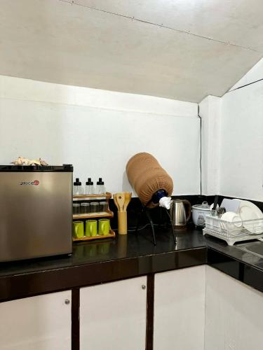 a kitchen with a black counter top with a counter sidx sidx sidx at Namastay Siargao in General Luna