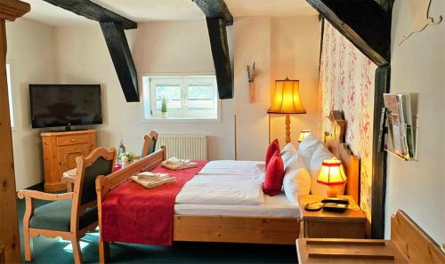 a bedroom with a bed and a desk and a television at Hotel Am Markt & Brauhaus Stadtkrug in Ueckermünde