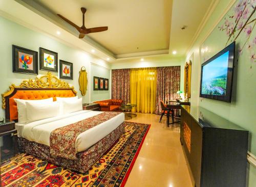 a hotel room with a bed and a flat screen tv at Mayfair Oasis Resort & Convention in Jhārsuguda