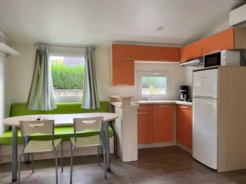 a small kitchen with a table and chairs in it at ZEcamping 2 étoiles animaux acceptés dans un environnement calme et naturel in Angicourt