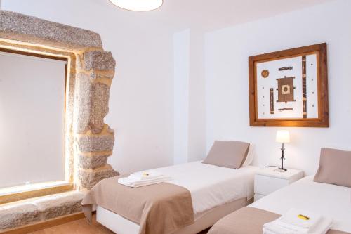 a room with two beds and a window at Moinhos do Pisão in Povoa Dao
