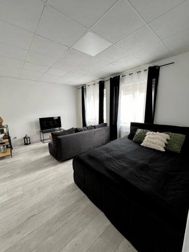 a living room with a bed and a couch at Nowoczesny Apartament w Prudniku in Prudnik
