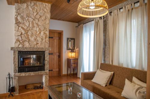 a living room with a couch and a fireplace at Moinhos do Pisão in Povoa Dao