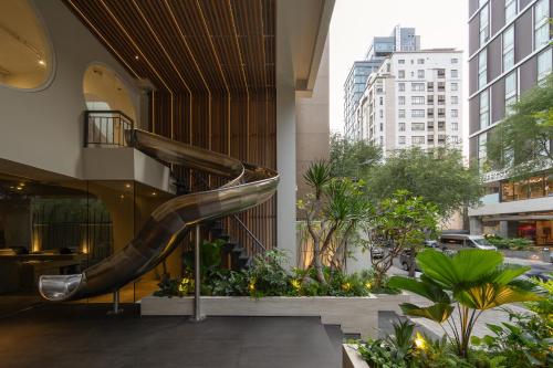 a spiral staircase in a building with plants at MEANDER Saigon in Ho Chi Minh City