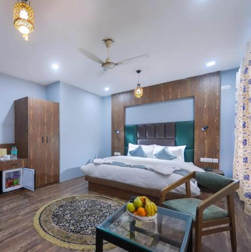 a bedroom with a king sized bed and a table at Hotel Your Hive in Srinagar