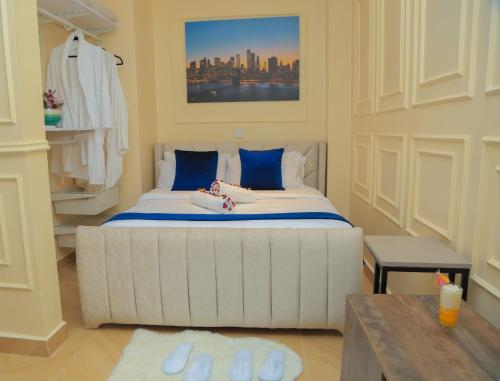 a bedroom with a large white bed with blue pillows at Executive-Studio-Apartmen in Nairobi