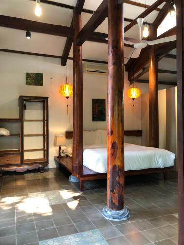 two beds in a room with wooden beams at Anicca Riverside Cottage in Thanh Ðông (1)