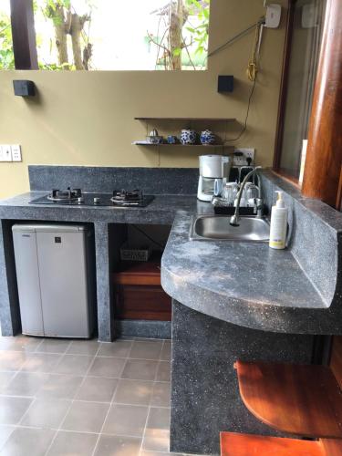 a kitchen with a sink and a counter top at Anicca Riverside Cottage in Thanh Ðông (1)