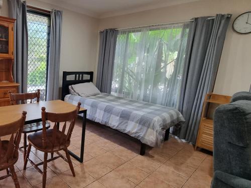 a bedroom with a bed and a table and a window at Theme Park Getaway in Gold Coast